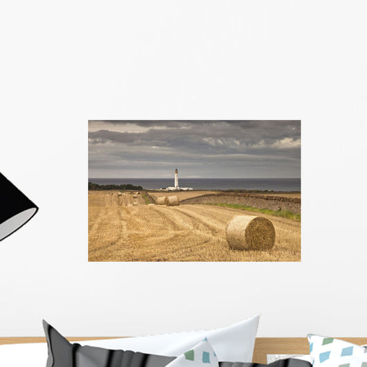 Barns Ness Lighthouse Along The Coast And Hay Bales In A Field Wall Mural