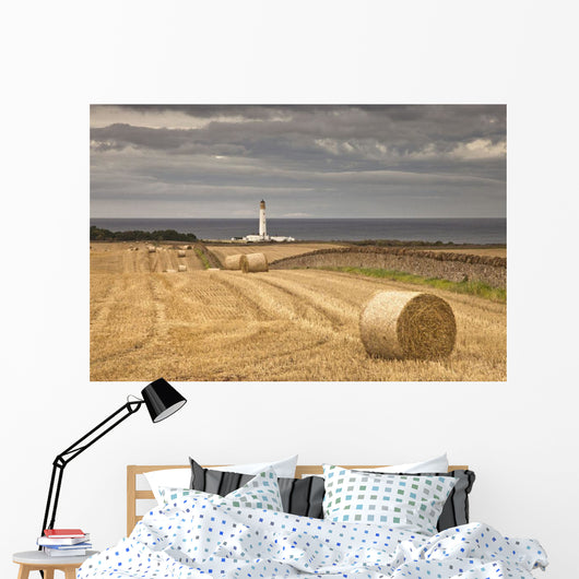 Barns Ness Lighthouse Along The Coast And Hay Bales In A Field Wall Mural