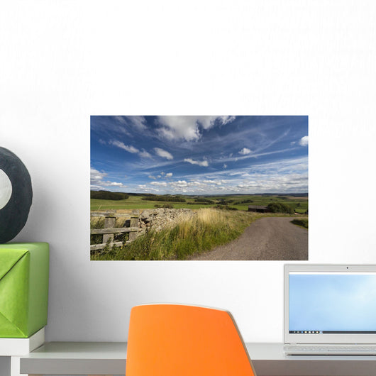 A Country Road With A Hilly Landscape Wall Mural
