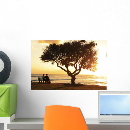 Beautiful Sunset Over The Ocean With A Couple Sitting On A Bench Wall Mural