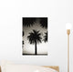 Silhouetted palm tree centered between other palm tree tops at dusk Wall Mural