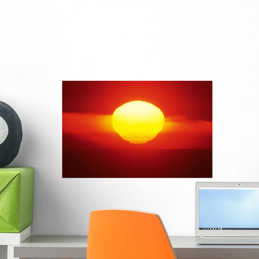 Gorgeous Sun Setting In Bright Orange Sky Over Ocean Wall Mural