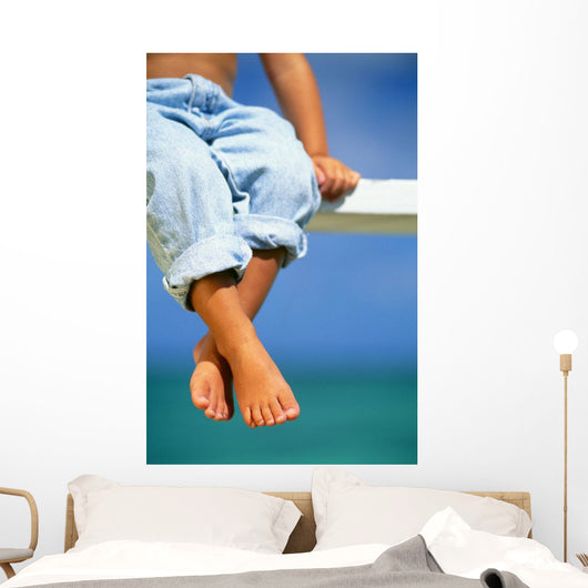 Hawaii, Legs And Feet Of Young Boy Sitting On A Bench By The Ocean Wall Mural