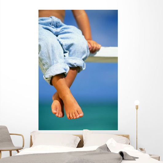 Hawaii, Legs And Feet Of Young Boy Sitting On A Bench By The Ocean Wall Mural