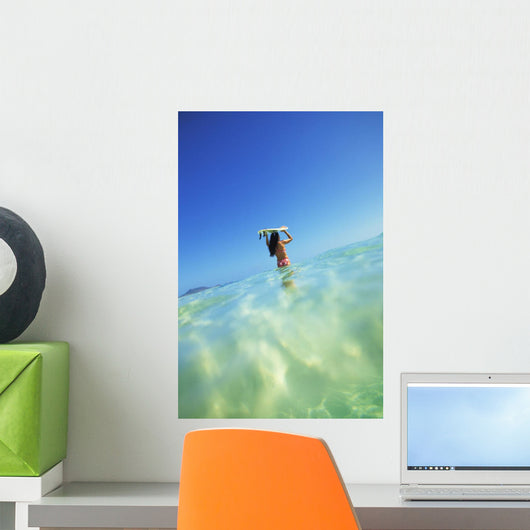 Over/Under View Of Woman Holding Surfboard On Head Wall Mural