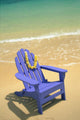 Blue Chair Along Shoreline With Plumeria Lei Hanging On Side Wall Mural