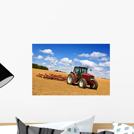 Tractor in plowed field Wall Mural