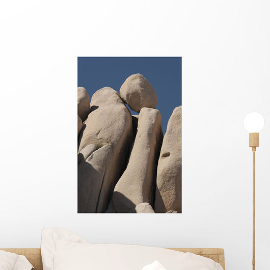 Round Boulder On Top Of Rounded Rock Cliff And Blue Sky Wall Mural