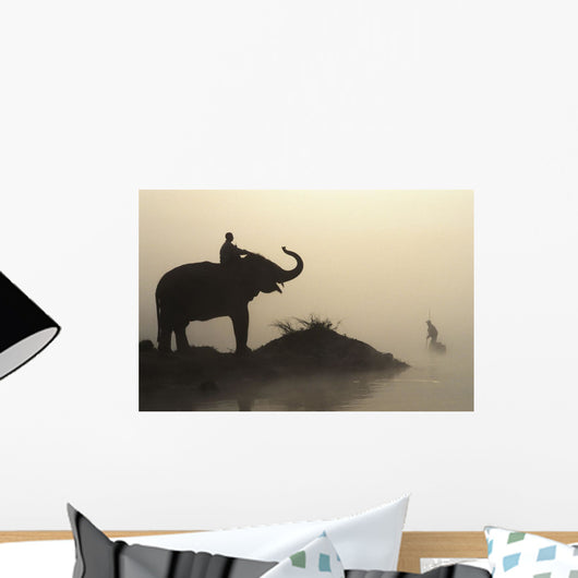 An Elephant With Its Mahout Stand At The Edge Of The Rapti River Wall Mural