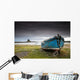 A Weathered Boat Sitting On The Shore With Lindisfarne Castle Wall Mural