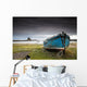 A Weathered Boat Sitting On The Shore With Lindisfarne Castle Wall Mural