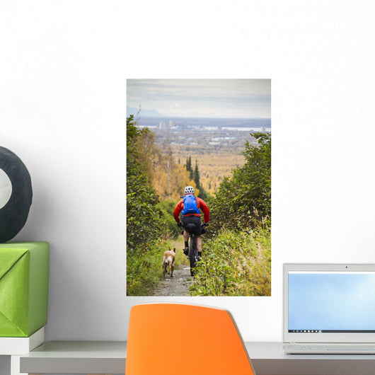 Man Mountain Biking With Dog Running Beside Him Wall Mural