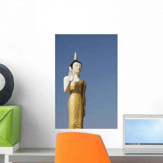 Laos, Vientiane, Wat That Luang Neua, Buddha statue against blue sky Wall Mural