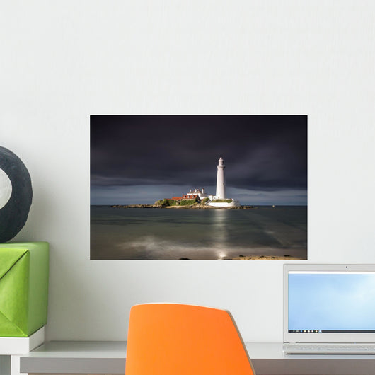 White Lighthouse Illuminated By Sunlight Under A Dark Stormy Sky Wall Mural