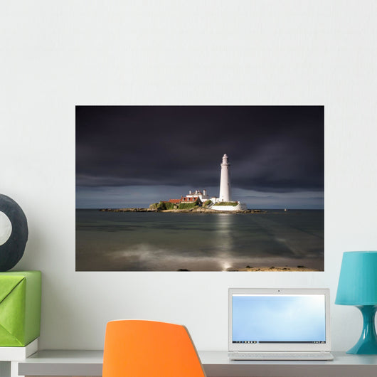 White Lighthouse Illuminated By Sunlight Under A Dark Stormy Sky Wall Mural