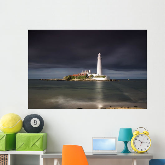White Lighthouse Illuminated By Sunlight Under A Dark Stormy Sky Wall Mural