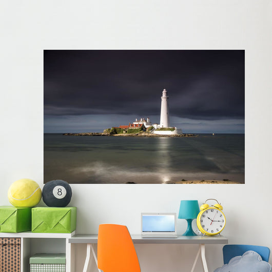 White Lighthouse Illuminated By Sunlight Under A Dark Stormy Sky Wall Mural