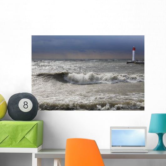 Storm waves crashing on a beach near a lighthouse on lake ontario Wall Mural