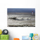 Storm waves crashing on a beach near a lighthouse on lake ontario Wall Mural
