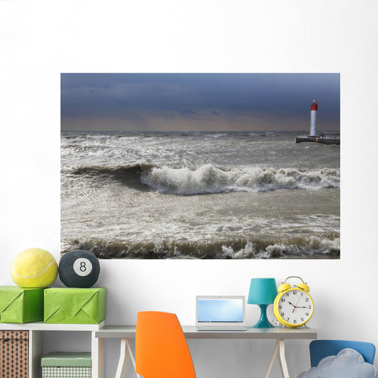 Storm waves crashing on a beach near a lighthouse on lake ontario Wall Mural