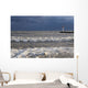 Storm waves crashing on a beach near a lighthouse on lake ontario Wall Mural