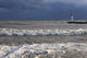 Storm waves crashing on a beach near a lighthouse on lake ontario Wall Mural