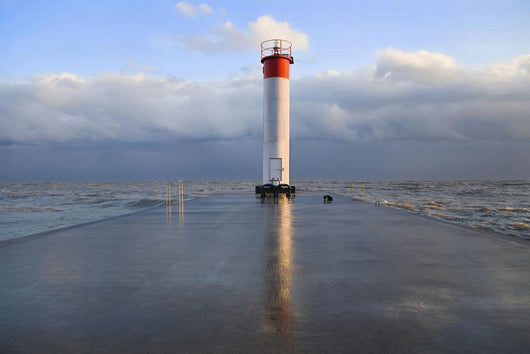 Lighthouse reflected on a wet pier on a stormy day by lake ontario Wall Mural