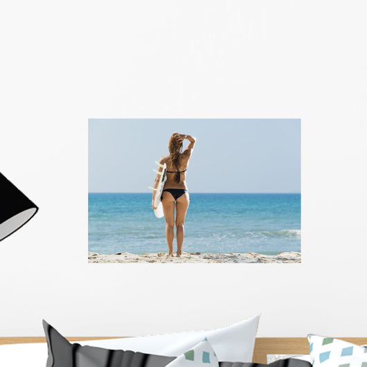 A woman wearing a black bikini stands Wall Mural