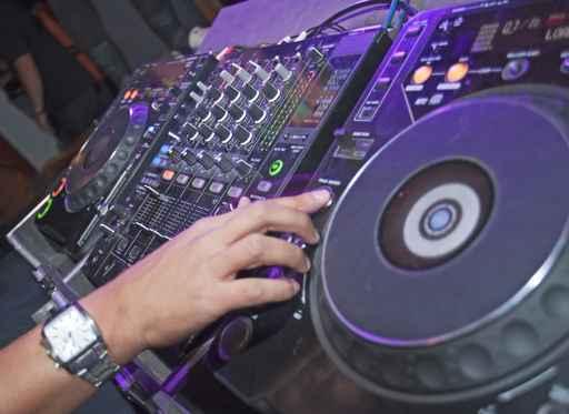 DJ mixing music on a mixer desk Wall Mural
