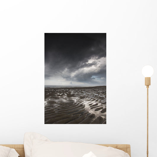 Rippled sand under a dark cloud Wall Mural