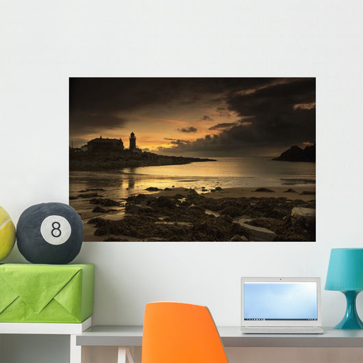 Silhouette of a lighthouse along the coast Wall Mural