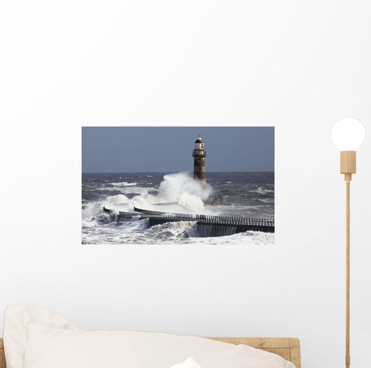 Waves crashing into a lighthouse Wall Mural