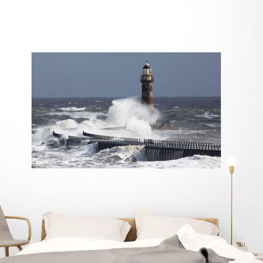 Waves crashing into a lighthouse Wall Mural