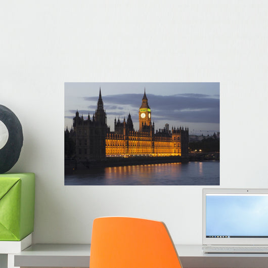 A Building And Clock Tower Along The Water's Edge Illuminated At Dusk Wall Mural