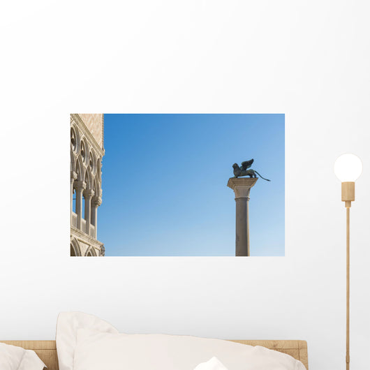 Statue on top of a column monument against a blue sky Wall Mural