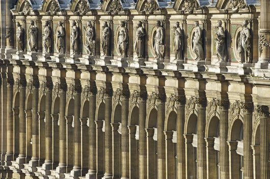 Ornate facade of a building with columns and statues of men in a row Wall Mural