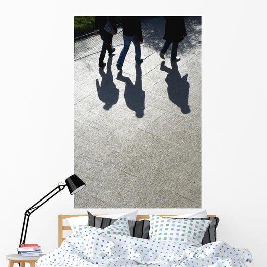Pedestrians and their shadows on a walkway Wall Mural