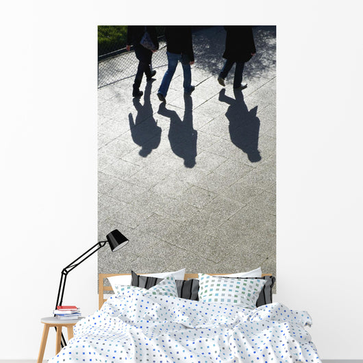 Pedestrians and their shadows on a walkway Wall Mural