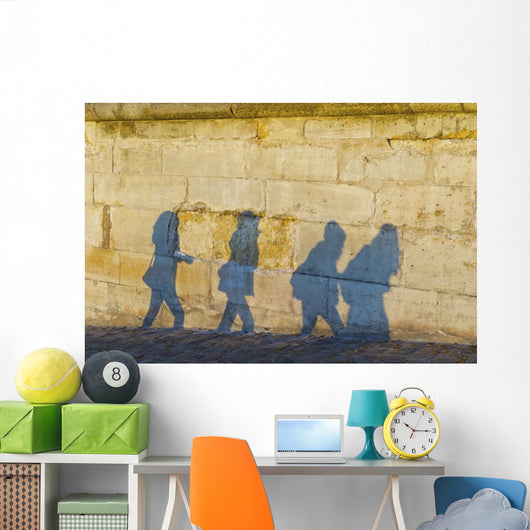 Shadows of pedestrians cast on a wall Wall Mural