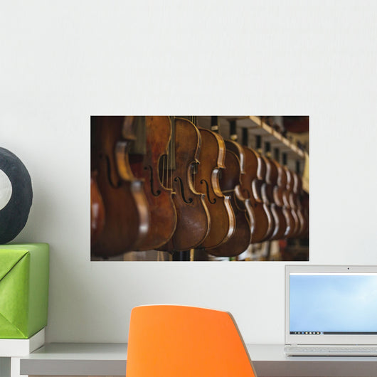 Repaired violins and violas on racks in The Sound Post repair shop Wall Mural
