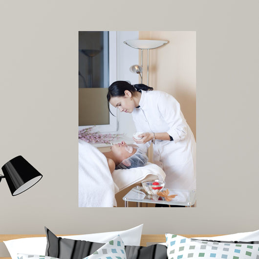 Beautician applying facial mask Wall Mural
