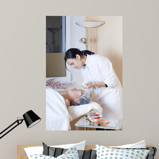 Beautician applying facial mask Wall Mural