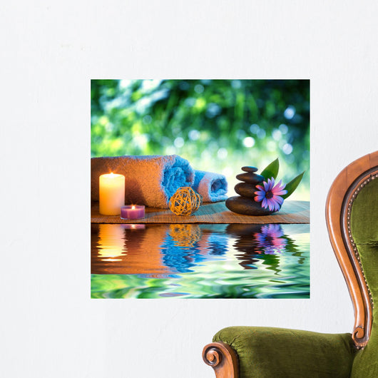 two candles and towels black stones and purple daisy on water Wall Mural