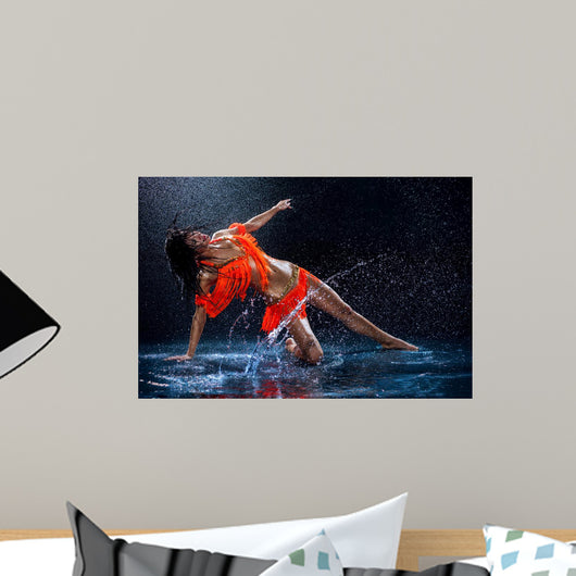 Woman dancing under rain in orange dress. Studio Wall Mural