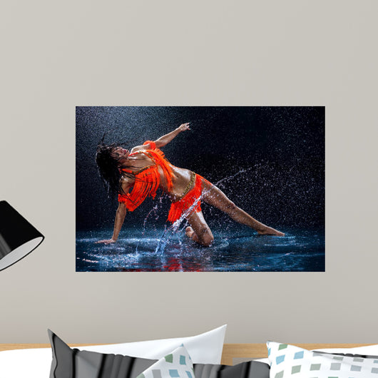 Woman dancing under rain in orange dress. Studio Wall Mural