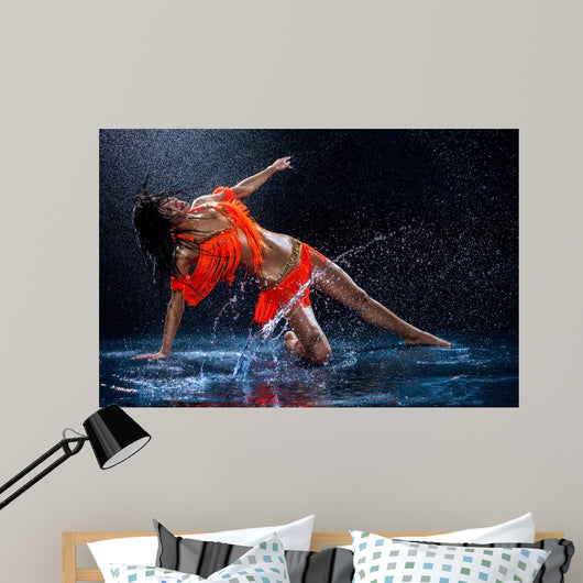 Woman dancing under rain in orange dress. Studio Wall Mural
