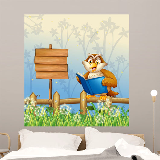 An owl reading a book beside a wooden signboard Wall Mural