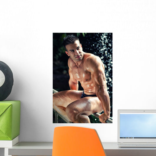 Muscular Wet Bodybuilder Sitting on Railing Wall Mural