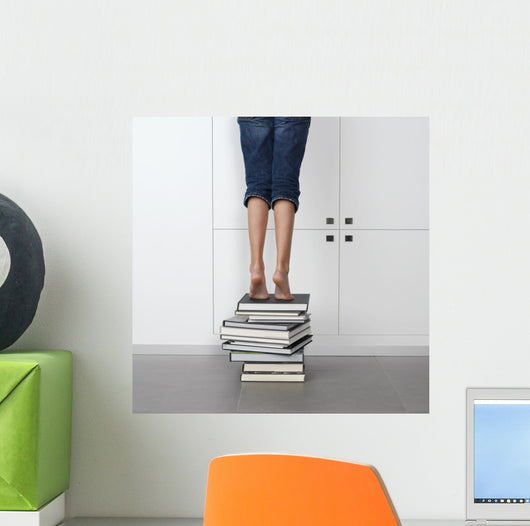 teenage girl standing on top of a stack of books Wall Mural