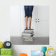 teenage girl standing on top of a stack of books Wall Mural